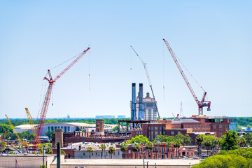 Savannah river waterfront with construction real estate development site by cranes and brick old town architecture in Savannah, Georgia southern city