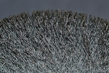 Wire wheel brush for grinder tool, detailed bristles partial closeup abstract.
