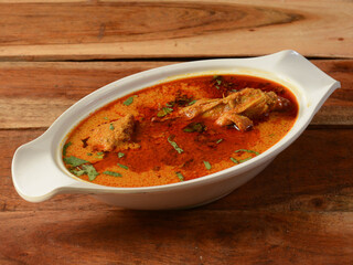 Chicken masala made of indian spices served in a bowl over a wooden rustic background. selective focus