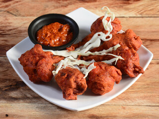 Chicken lollipop is Indian Chinese appetizer served over a wooden rustic background. selective focus