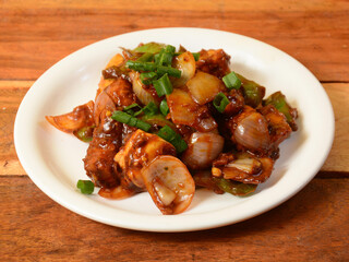 Chilli Chicken is an Indian Chinese starter served over a wooden rustic background. selective focus