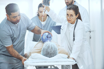 Patient lying with oxygen mask while doctors performing a reanimation with defibrillator at hospital