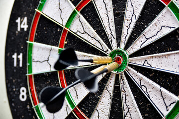 Dart board with darts in the center.
