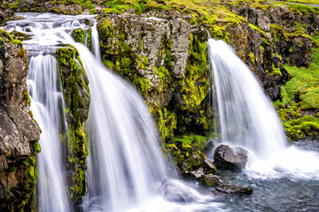 Grundarfjordur, Iceland Kirkjufell waterfall closeup smooth long exposure water on Snaefellsnes peninsula with green grass in summer