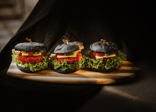 Vegetarische Black Bun Burger mit Linsen-Rote Beete Patties, K&auml;se, Tomaten und Salat.