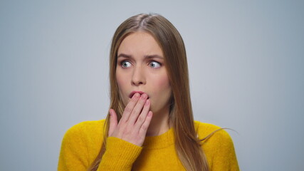 Closeup disappointed woman looking at camera on grey background in studio.