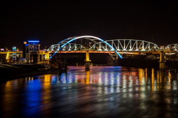 Obraz na płótnie Canvas The John Seigenthaler Pedestrian Bridge at night as seen from Cumberland Park looking back at the Nashville downtown and the Korean Veterans Blvd Bridge 
