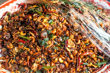Top view of Indian style dried cashew nuts with Chili and kaffir lime leaves at Ong Ang street art (the new walking street ) in Bangkok Thailand