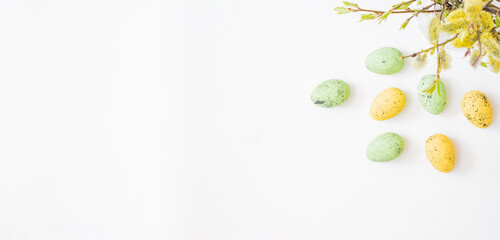 Flat lay easter composition with willow branches in a vase and easter eggs on a light background