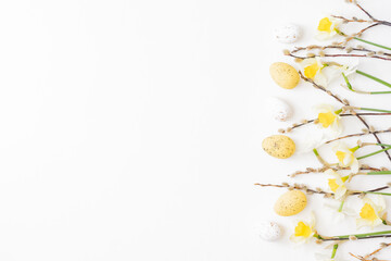 Flat lay easter composition with daffodils and eggs on white background