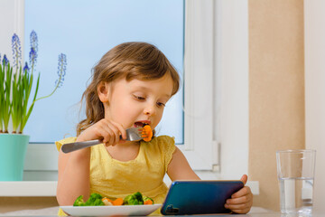 The child dictates his own rules and eats broccoli only with cartoons. Organic cabbage and food on a plate.