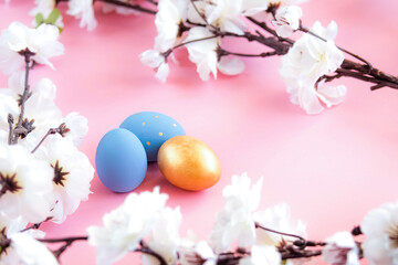 Blue and gold easter eggs on pink background