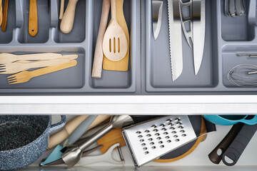 Open drawer with different utensils and cutlery in kitchen,  above view.