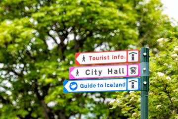 Reykjavik, Iceland street road in downtown center and sign by green trees park for directions to tourist information, city hall and guide to country