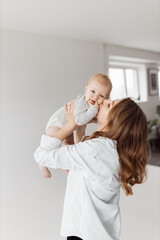 Joyful mother lift her adorable little daughter in the air, playing together. Beautiful woman with...