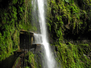 Waterfall crashing on a small shelter on the Levada da Ribeira da Janela, Madeira, Portugal