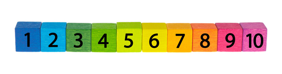 Bunte Holzwürfel liegen nebeneinander vor weißem Hintergrund.