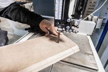 Craftsman using a jigsaw to cut a plank
