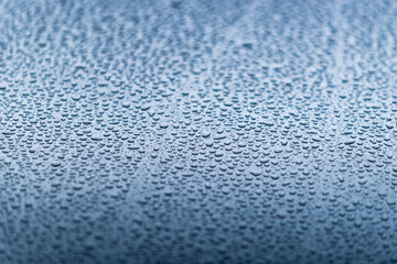 Water drops on blue metal surface.