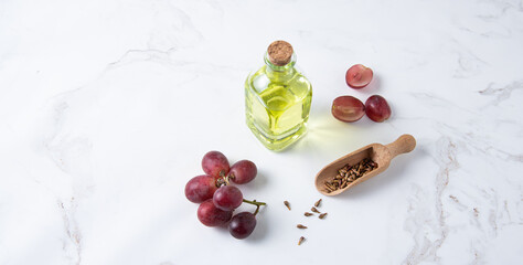 natural dietary and vegan grape seed oil in glass bottles on a white marble background. Healthy food and lifestyle