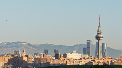 Panorama of the business district in northern part of Madrid city. Snow covered mountains visible in the distance of this image taken just after sunrise.