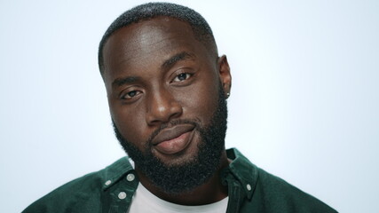Portrait of playful african american man flirting on camera in studio.