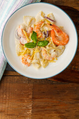 Pasta with shrimps in a creamy sauce on a plate with spinach