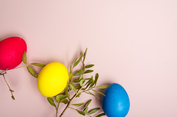 Coloured decorated easter eggs on a pastel pink background