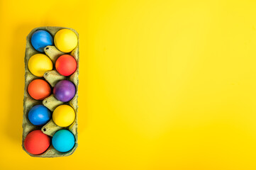 Fototapeta na wymiar Colorful Easter eggs, flat lay against a yellow background