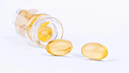 Foto op Canvas Medische gele pilcapsules en een glazen fles. Farmaceutisch geneesmiddel voor de gezondheid. © Albert Ziganshin