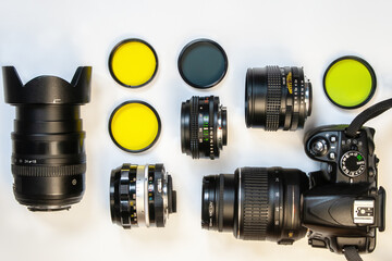 camera, set of photo lens and color optical filters on white background. Flat lay, top view.