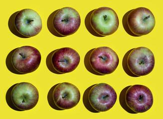 some apple fruits arranged on a yellow surface	