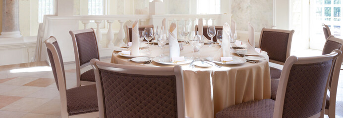 Festive covering table with wine glasses, guest cards and napkins
