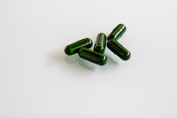 green pills on white glass table