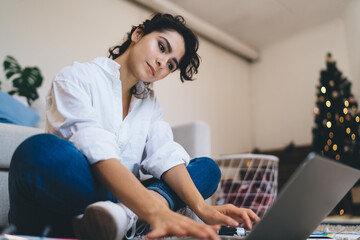 Young woman using laptop for remote work in Christmastime