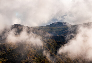 Fog in the green mountains, Azores travel destination.