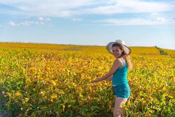 Fototapeta premium Young woman from Brazil showing a soy plantation-
