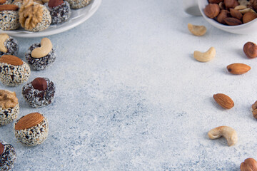 Organic non bake energy balls made of dried fruits and nuts on light background with copy space.