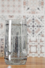 Glass of pure mineral water on kitchen table.