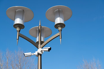 outdoor security camera on a lamppost against a blue sky