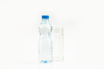 Water bottle and a glass of water against white background