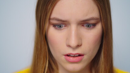 Closeup shocked attractive woman looking at camera on grey background.