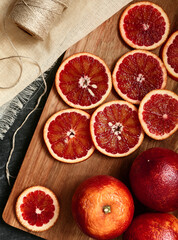 Red blood orange slice on a wooden board, top view