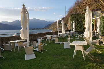 turn over tables and chairs on the shore of lake Maggiore, Ticino on a windy day