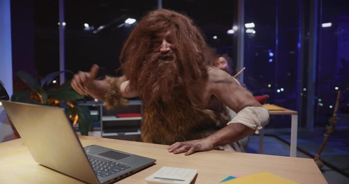 Tribal cave people couple entering modern world and working for business company. Successful neanderthal cavemen celebrating victory at work ma,ing money.