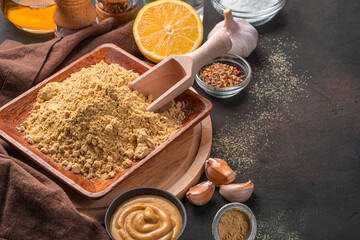 Mustard powder and spices on a dark background with space to copy.