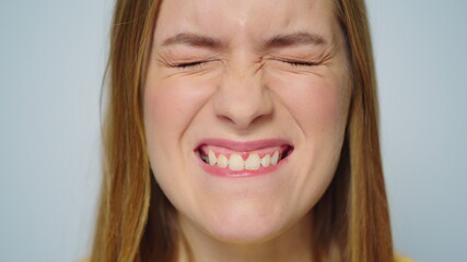 Closeup cheerful woman making funny faces on grey background in studio.