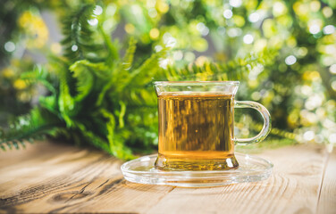 Tea cup on wooden table in front of floral spring garden nature outdoor