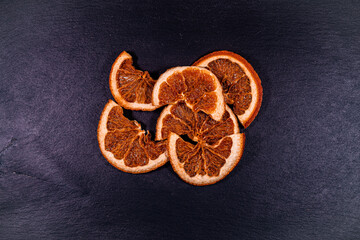 Dried orange slices on black background