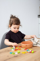 Child plays with beads and string. Fine motor skills development. Early education, Montessori Method